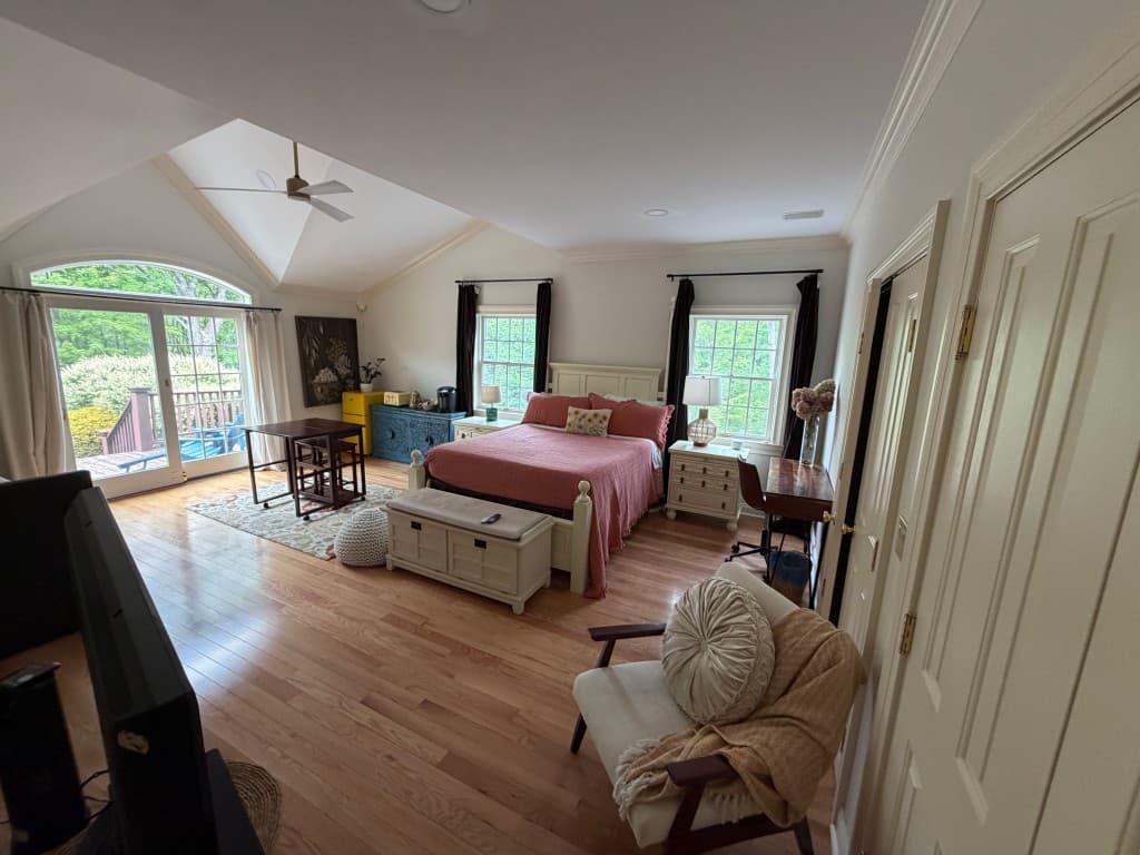 Spacious master bedroom with vaulted ceilings and private deck door